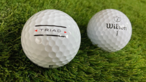 Wilson W/S Triad 2025 golf ball on grass showing dimples and logo